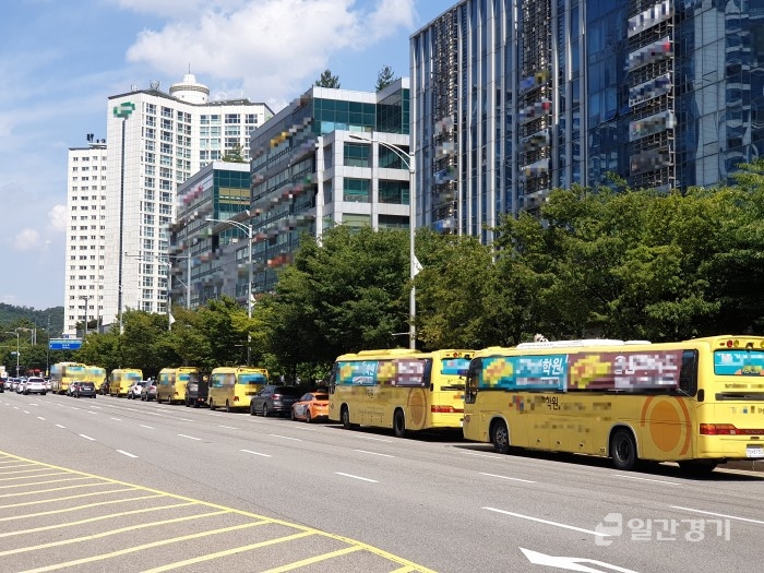 불법 광고 현수막을 설치한 학원차량들이 갓길에 한줄로 정차되어 있는 모습. &lt;사진 = 홍성은 기자&gt;