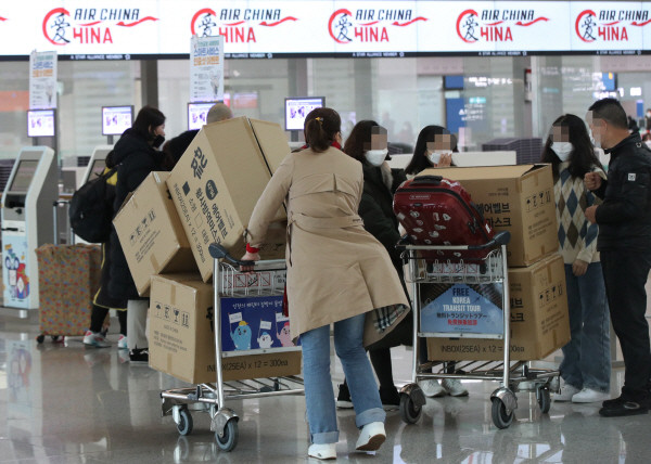 3일 오후 인천국제공항 1터미널에서 중국인 여행객들이 마스크 박스가 실린 카트를 밀고 탑승수속대로 향하고 있다. 3일 경찰은 마스크 매점매석 행위가 심각할 경우 관계기관과 협력해 수사에 나서겠다고 밝혔다. (사진=연합뉴스)