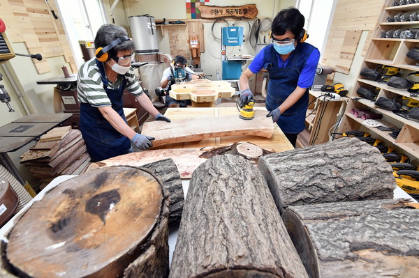수원시 숲 자원화 사업단이 목공체험장에서 버려진 고사목을 활용한 시설물을 만들고 있다. (사진=수원시)