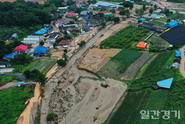 많은 비가 내려 2일 오전 둑 일부가 무너진 경기 이천시 산양저수지 부근 마을이 토사로 덮여 있다.