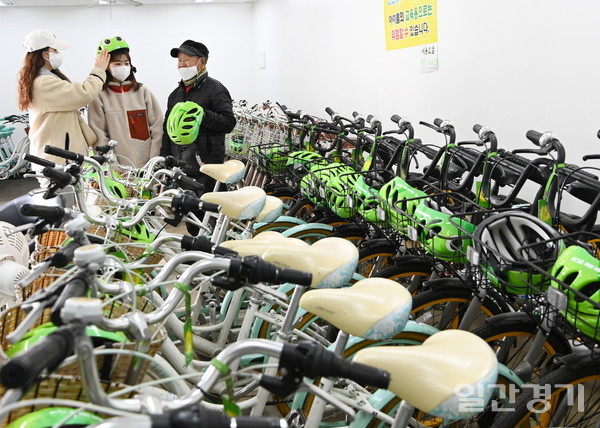 광교산 입구에 위치한 자전거대여소 반디클에서 시민이 자전거와 안전모를 빌리고 있다. (사진=수원시)