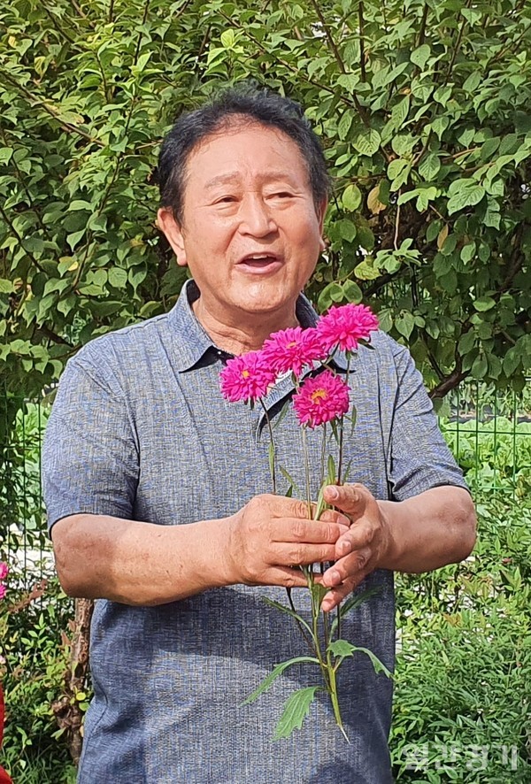꽃을 들고 노래를 부르고 있는 정군영 두선산업 회장 (사진=박웅석 기자)