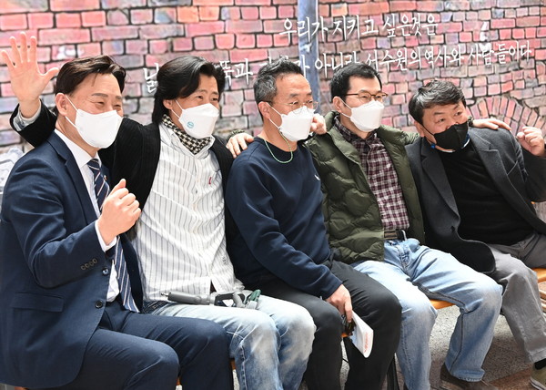 ‘영신연와를 지키는 수원시민모임’에 참여하고 있는 지역 작가들이 수원시청 로비에서 전시회를 열며 기념촬영을 하고 있다. (사진=수원시)