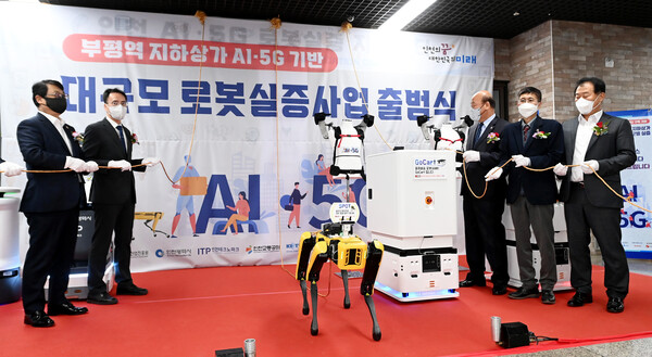 25일 부평지하상가에서 열린 '부평역 지하상가 AI·5G 기반 대규모 로봇실증사업 출범식'에서 내빈과 로봇이 현판을 제막하고 있다.