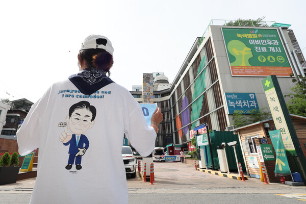 24일 오후 더불어민주당 이재명 대표가 회복 치료를 받고 있는 서울 중랑구 녹색병원 앞에서 한 지지자가 응원 피켓을 들고 서 있다. (사진=연합뉴스)