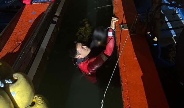 해양경찰 구조대가 어선사이에서 익수자 여성을 구조하고 있다.(2) (2)