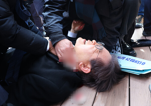 이재명 민주당 대표가 1월 2일 오전 부산 강서구 가덕신공항 부지를 둘러본 뒤 왼쪽 목 부위 피습을 당해 바닥에 누워 병원 호송을 기다리고 있다.