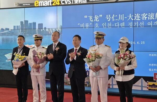 인천항만공사가 인천항과 중국 대련을 오가는 한중 국제카페리 첫 여객과 선장에게 꽃다발을 전달하고 기념촬영을 하고 있다 (사진=인천항만공사)